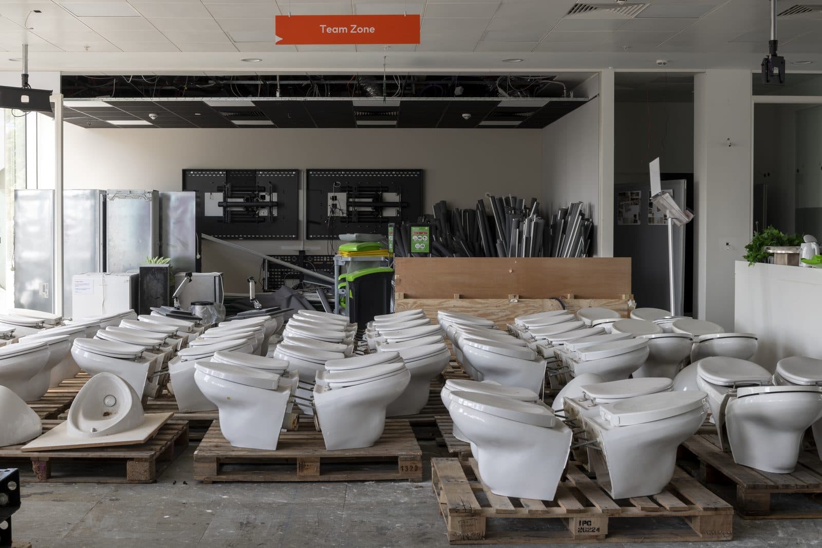 Reclaimed basins and sanitaryware stacked on pallets during a strip-out