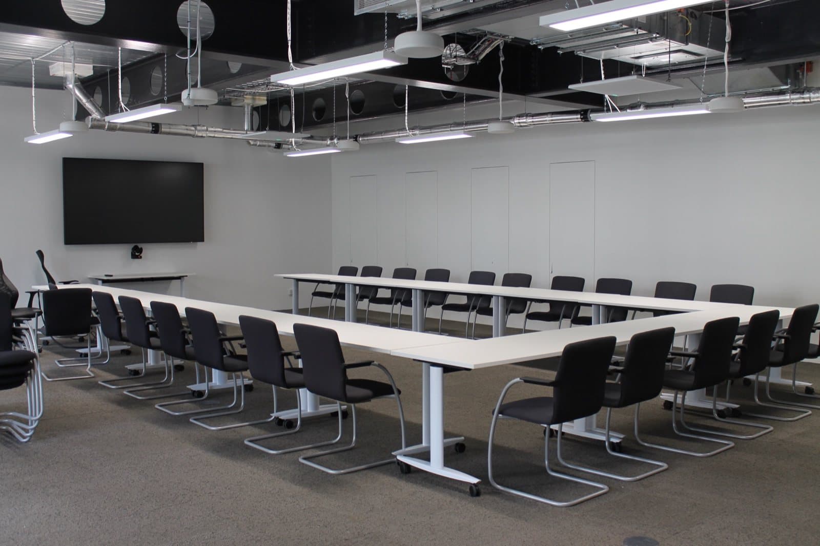 A training room set out with reclaimed tables and stacking chairs at 2 Aldermanbury Square