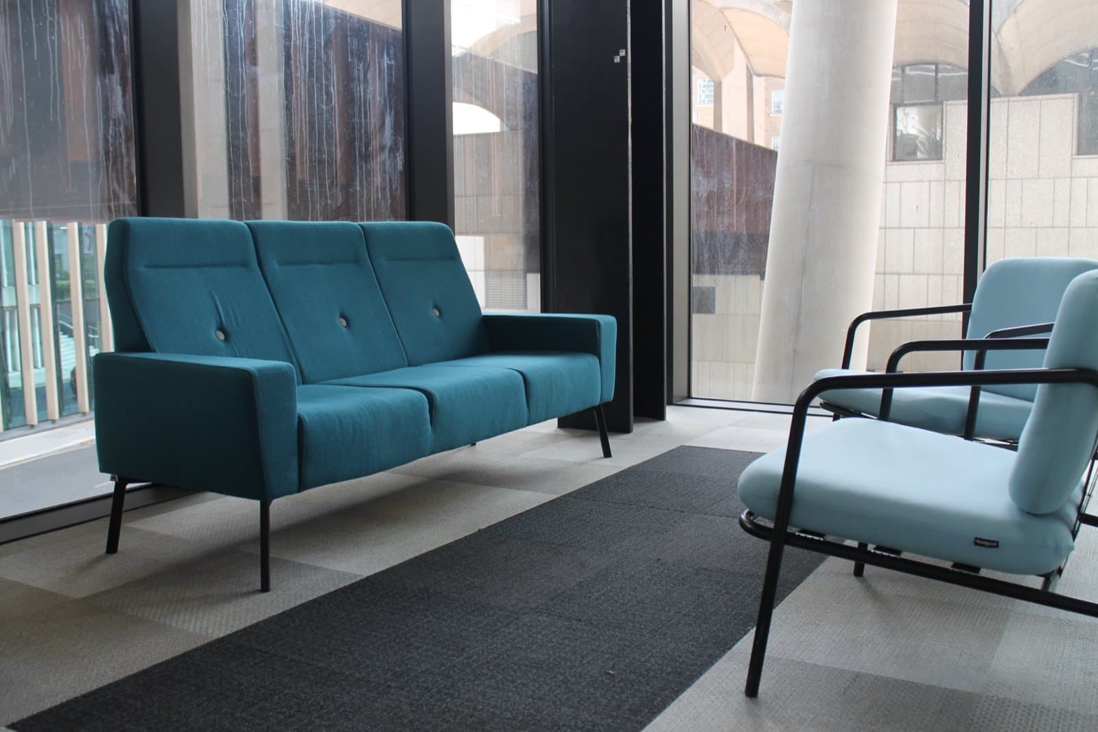 Reclaimed sofas and armchairs by the windows of the site welfare area