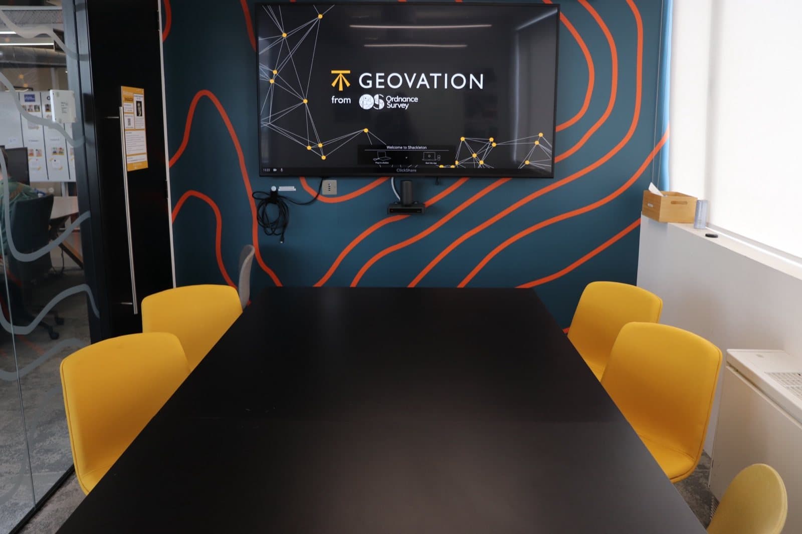 Yellow meeting chairs around the table in a Geovation Hub meeting room