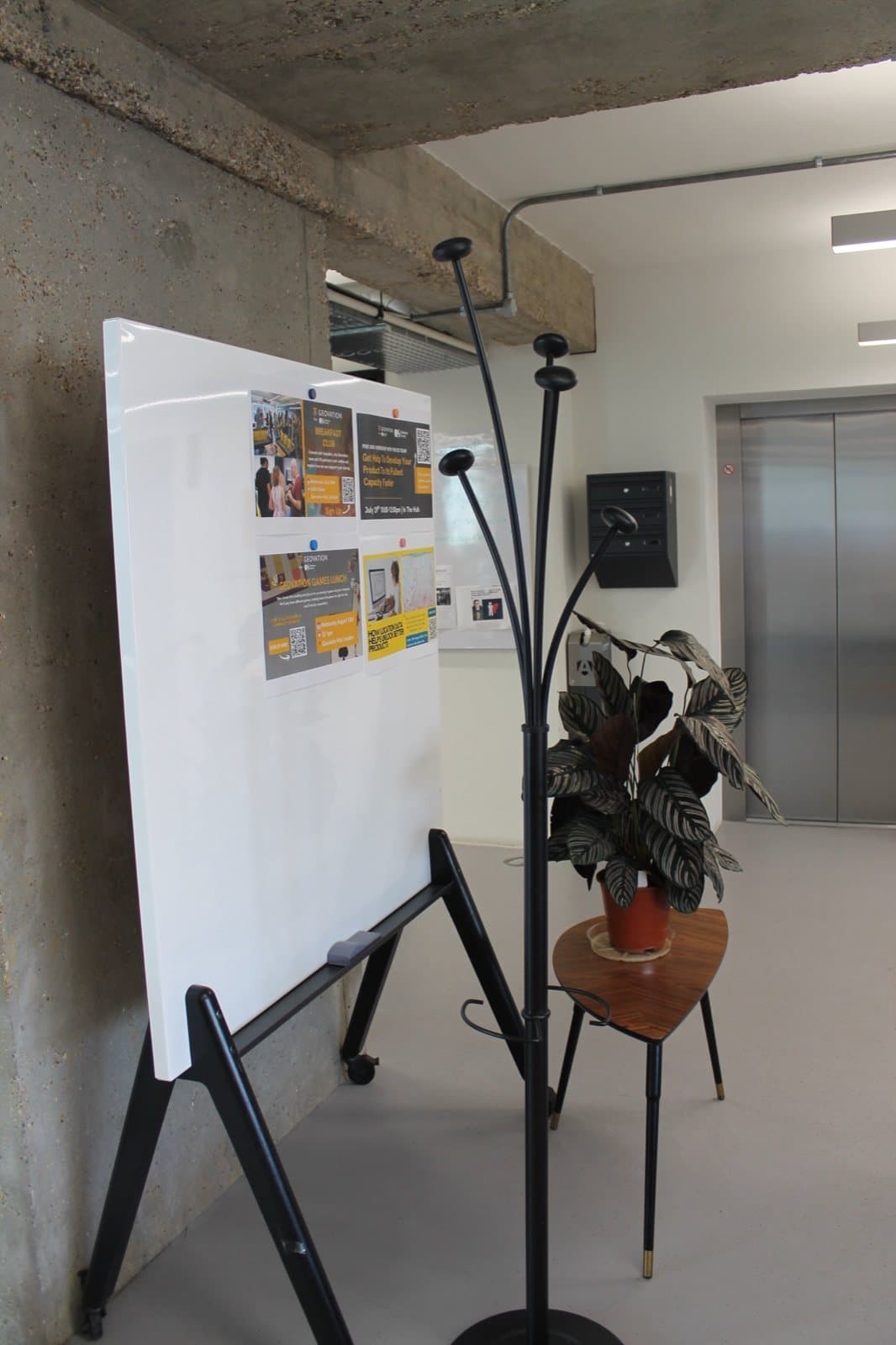A reclaimed mobile whiteboard and coat stand in the Geovation Hub