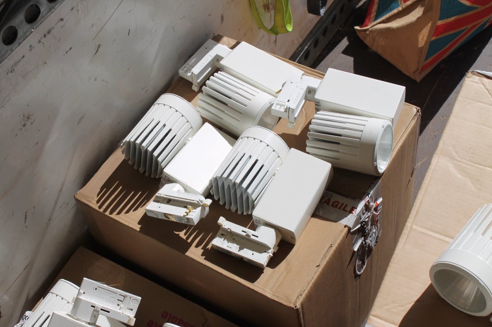 Reclaimed track spotlights boxed for refurbishment before delivery