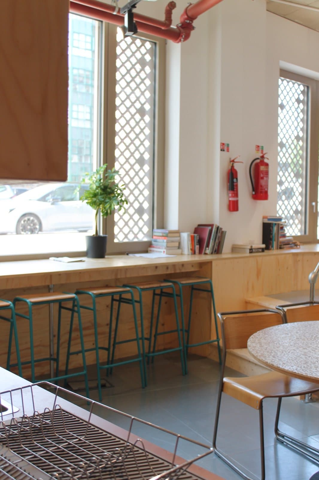 High stools at the plywood window counter in the Lisson Arches breakout space