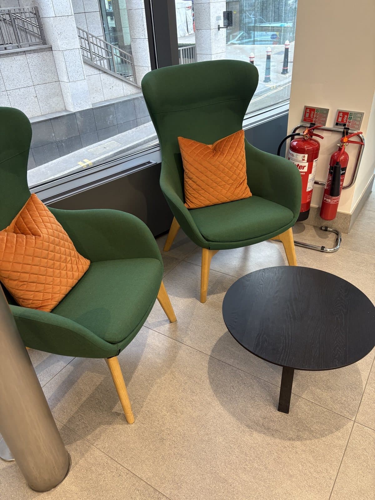 Green lounge chairs and a coffee table in a Peninsular House breakout space