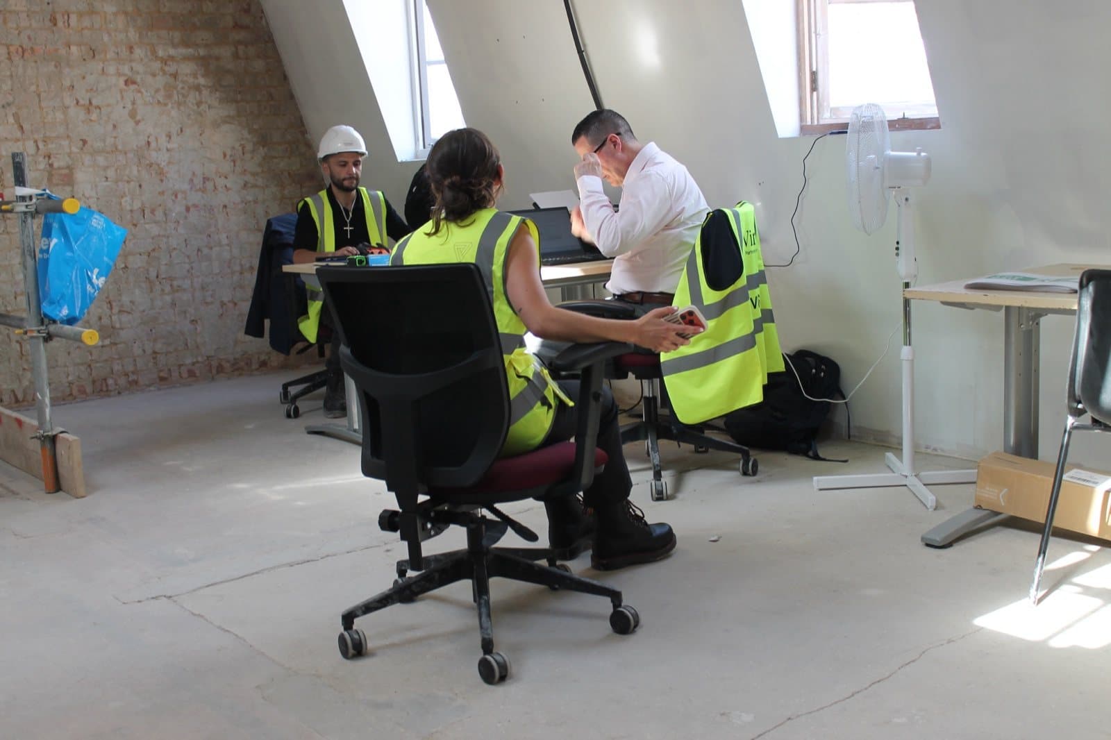 The Virtus team at reclaimed desks and task chairs in the Smithfield site office