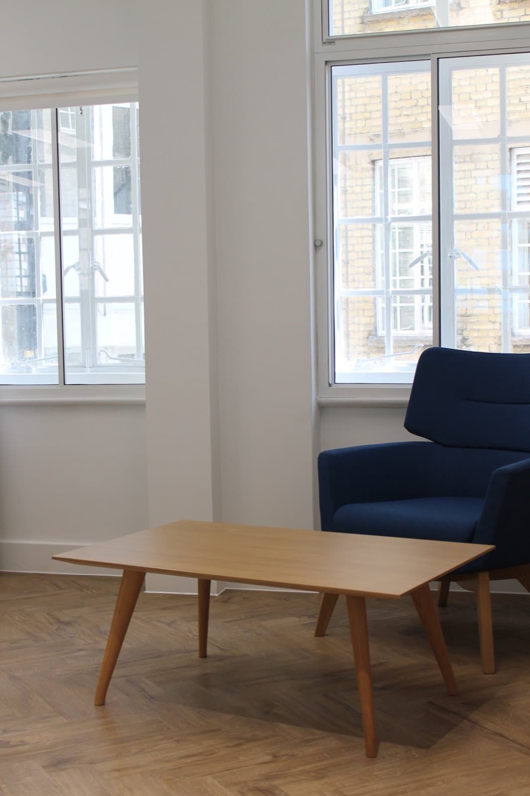 A reclaimed blue armchair and timber coffee table at Wates SES