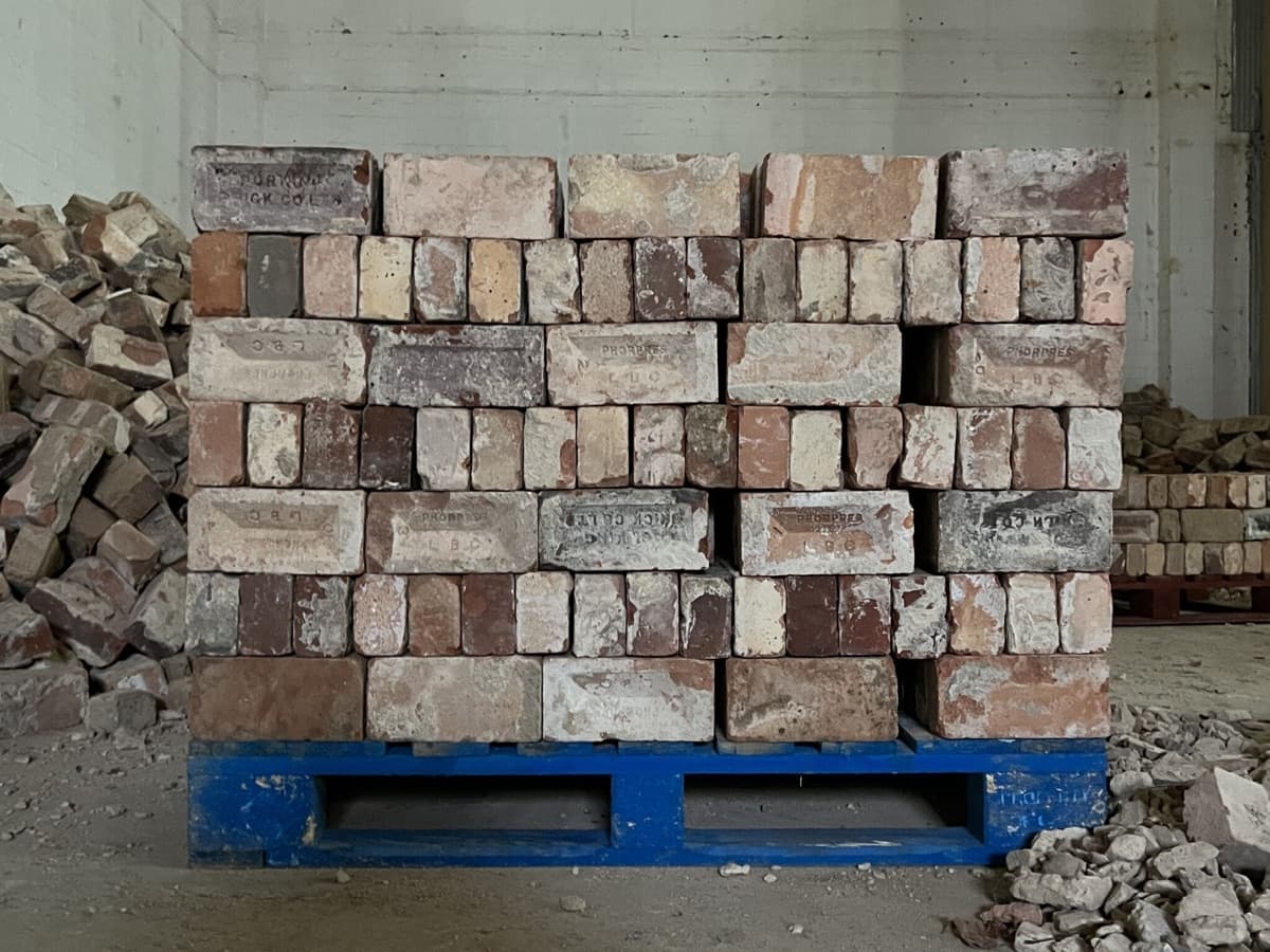 Reclaimed bricks stacked on a pallet on a demolition floor